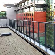 Edgetec Commercial fully framed glass balustrade, face fixed with round handrail